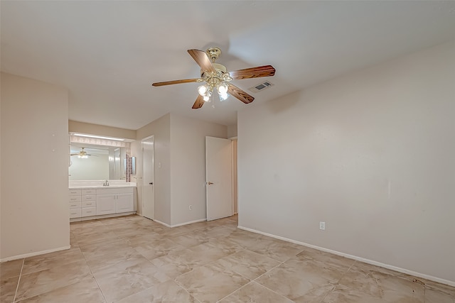 unfurnished bedroom featuring connected bathroom and ceiling fan