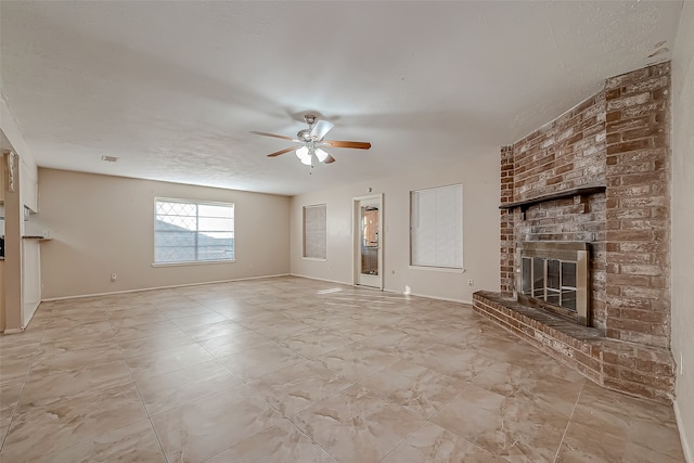 unfurnished living room with ceiling fan, a fireplace, and a textured ceiling