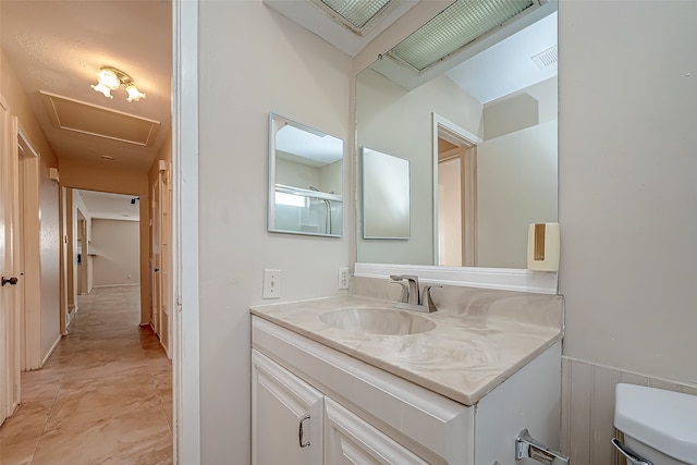 bathroom featuring vanity, toilet, and wood walls