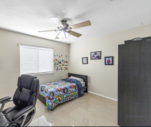 bedroom featuring ceiling fan and a textured ceiling