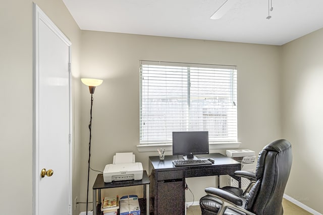 home office featuring a healthy amount of sunlight, ceiling fan, and carpet flooring