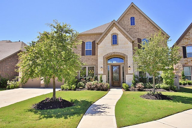 27827 Ramble Rock Ct, Katy, TX 77494 - french country home featuring stone siding, brick siding, concrete driveway, and a front lawn