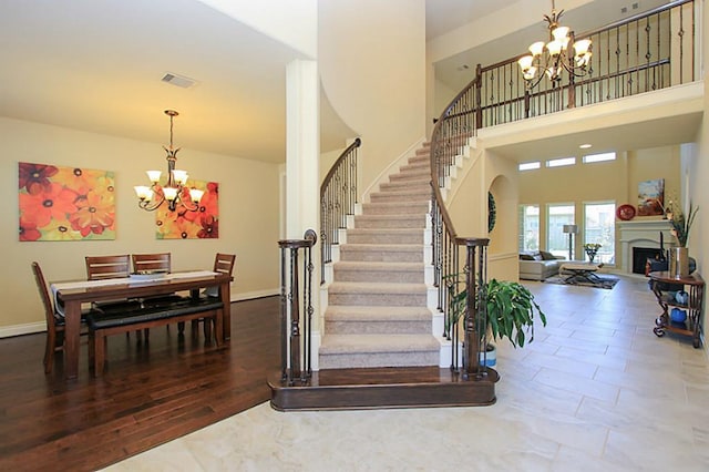 27827 Ramble Rock Ct, Katy, TX 77494 - stairway featuring a chandelier, a fireplace, a towering ceiling, and baseboards