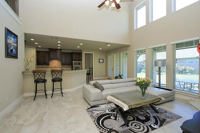 27827 Ramble Rock Ct, Katy, TX 77494 - living area featuring ceiling fan, a towering ceiling, baseboards, and recessed lighting