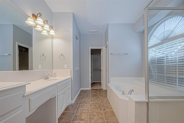 bathroom featuring tiled bath and vanity