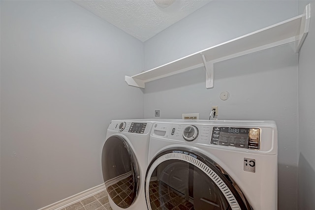 laundry area with separate washer and dryer and a textured ceiling