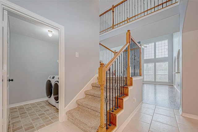 interior space with light tile patterned floors, separate washer and dryer, and a high ceiling