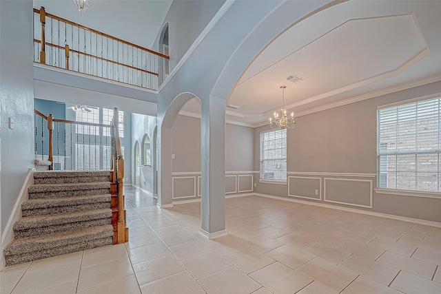 interior space featuring a notable chandelier, light tile patterned floors, and crown molding