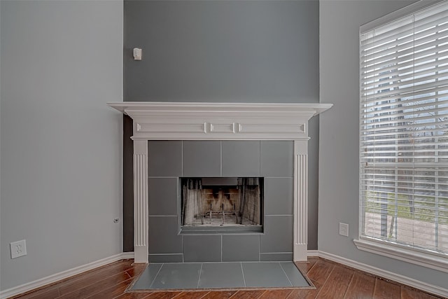 room details featuring wood-type flooring and a tiled fireplace