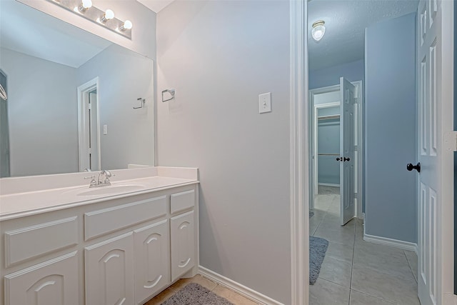 bathroom featuring tile patterned floors, vanity, and a textured ceiling