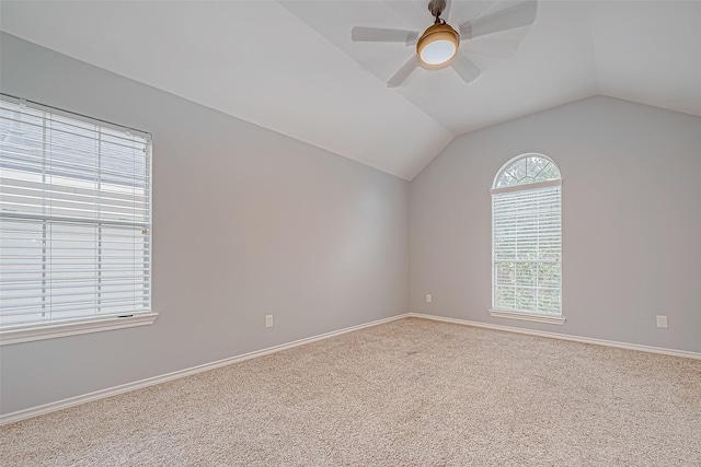 empty room featuring carpet, ceiling fan, and vaulted ceiling