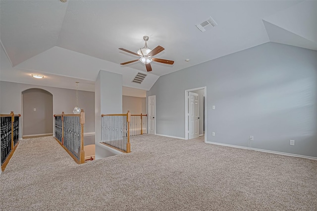 carpeted spare room featuring ceiling fan and lofted ceiling