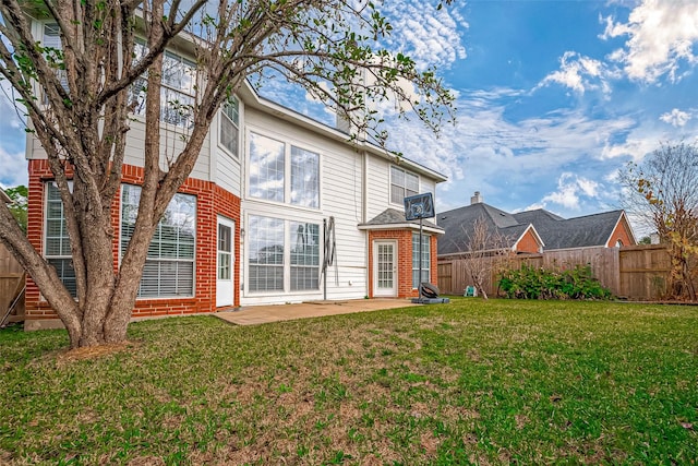 back of property featuring a lawn and a patio