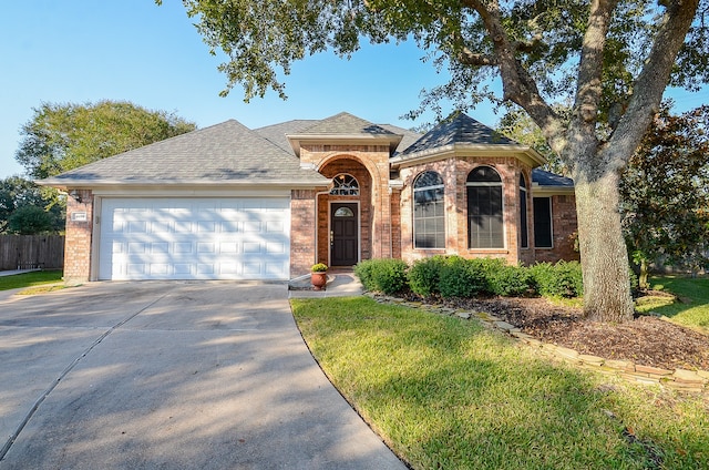 single story home featuring a garage and a front lawn