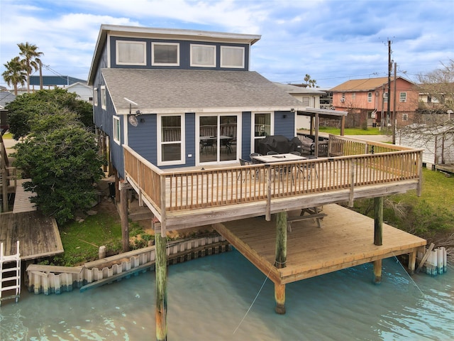 back of property featuring a deck with water view