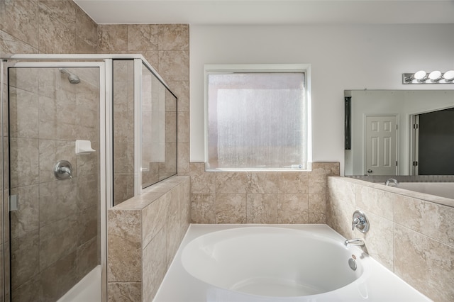 bathroom featuring a healthy amount of sunlight and separate shower and tub