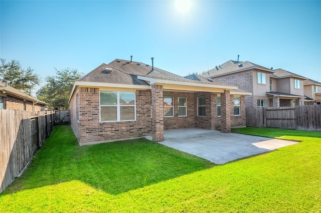 back of property with a yard and a patio