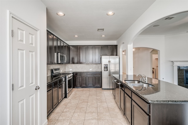 kitchen with stainless steel appliances, backsplash, sink, washer and dryer, and a fireplace