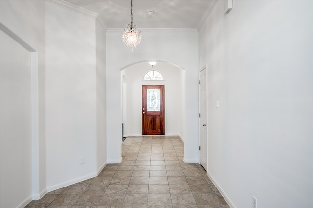 entryway featuring crown molding and a notable chandelier