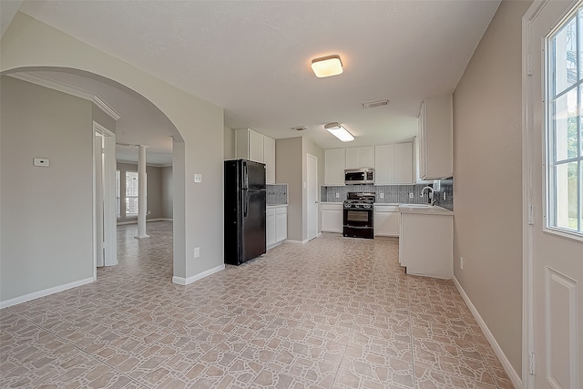 kitchen with a healthy amount of sunlight, black appliances, white cabinetry, and backsplash