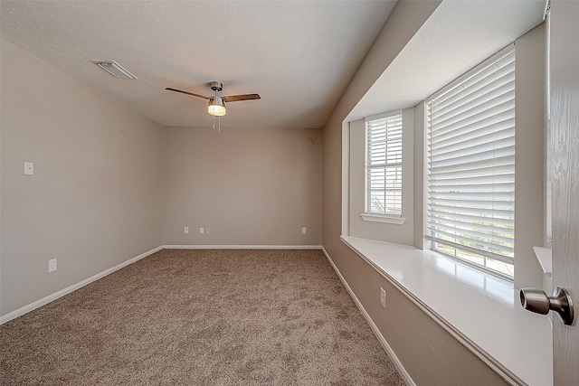 empty room featuring ceiling fan, carpet, and a textured ceiling