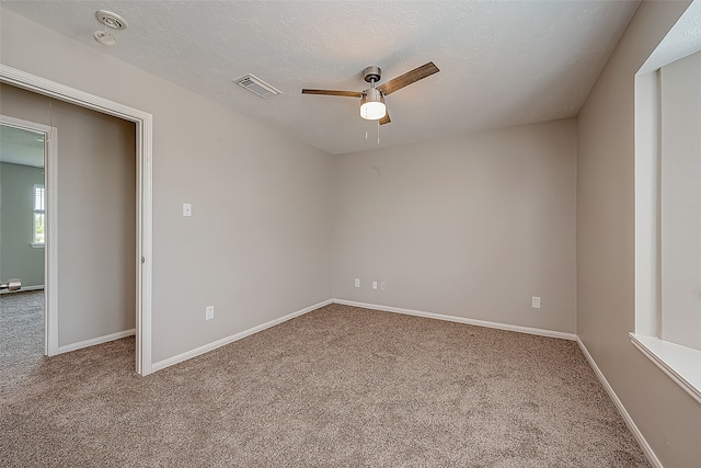 empty room with carpet floors, a textured ceiling, and ceiling fan