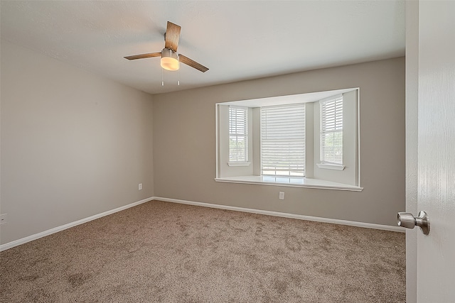 carpeted spare room featuring ceiling fan