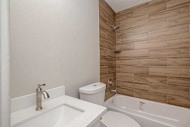 full bathroom with tiled shower / bath, vanity, toilet, and a textured ceiling