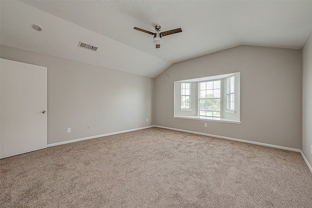 empty room with vaulted ceiling, carpet flooring, and ceiling fan