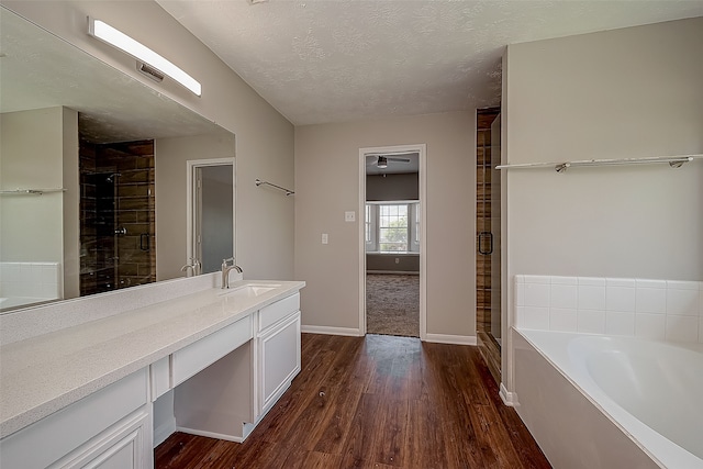 bathroom featuring hardwood / wood-style floors, vanity, independent shower and bath, and a textured ceiling