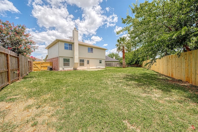 back of property featuring a yard and central AC