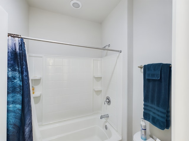 bathroom with shower / tub combo with curtain and toilet