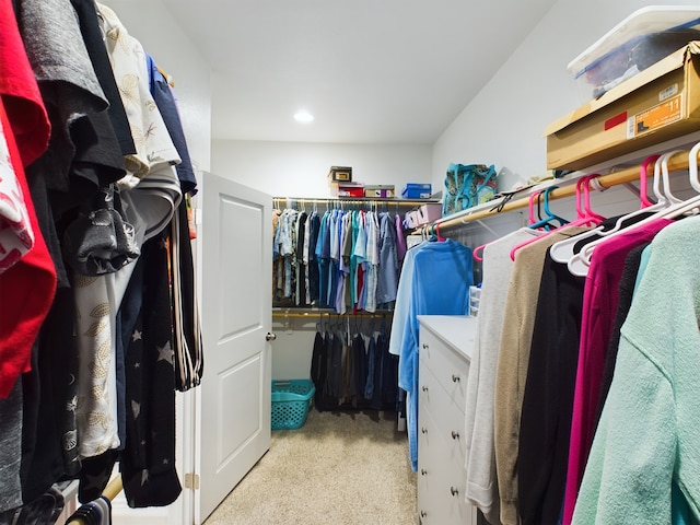 walk in closet featuring light colored carpet