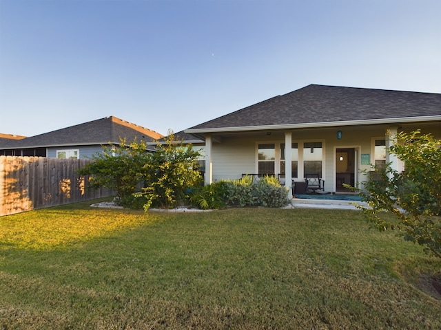 back of house with a lawn