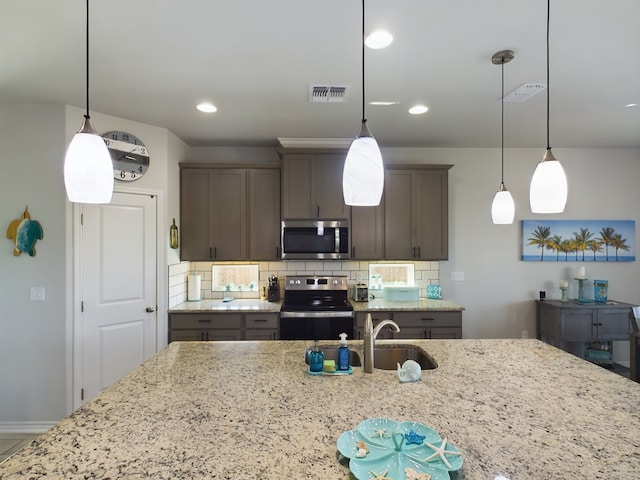 kitchen featuring hanging light fixtures, sink, stainless steel appliances, and tasteful backsplash