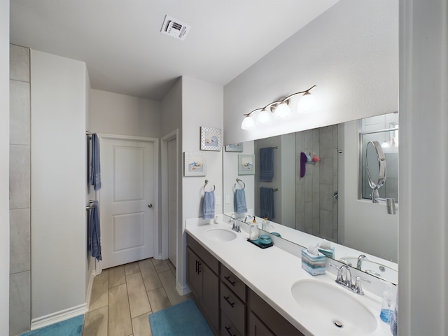 bathroom featuring a shower with door and vanity