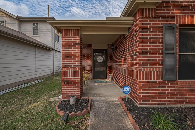 doorway to property with brick siding