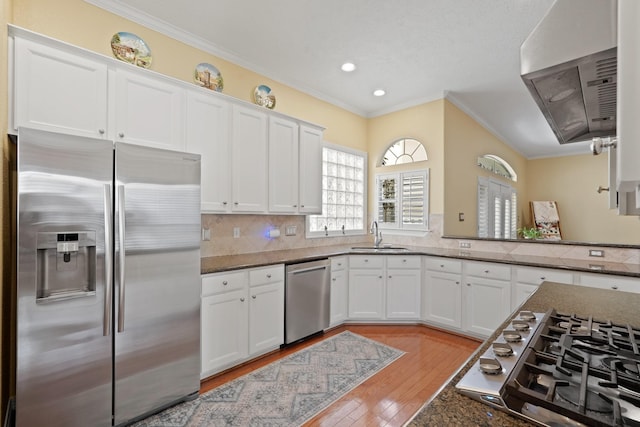 kitchen with sink, white cabinets, stainless steel appliances, and ornamental molding