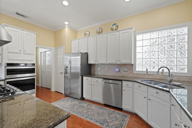 kitchen featuring sink, white cabinets, stainless steel appliances, and ornamental molding