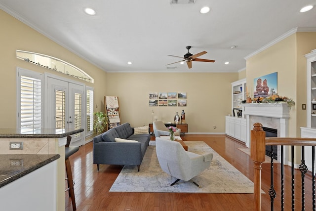 living room featuring crown molding, french doors, ceiling fan, and wood-type flooring