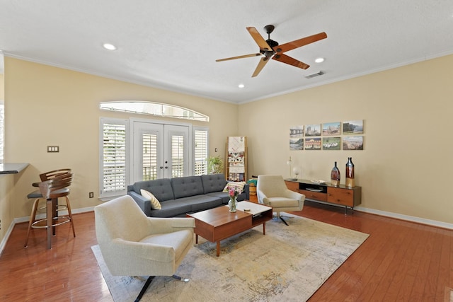 living room with crown molding, french doors, ceiling fan, and hardwood / wood-style flooring