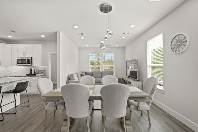 dining space with a wealth of natural light, light hardwood / wood-style flooring, and ceiling fan