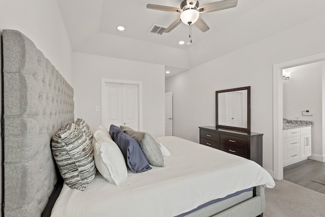 bedroom featuring connected bathroom, ceiling fan, a closet, and hardwood / wood-style flooring