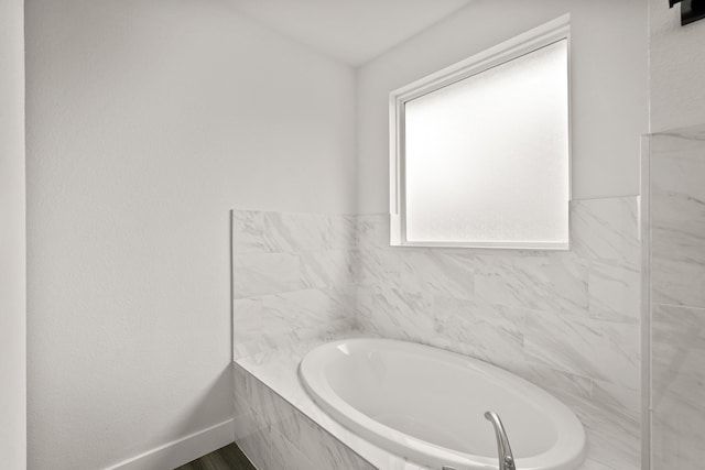 bathroom with a bathtub and tile walls