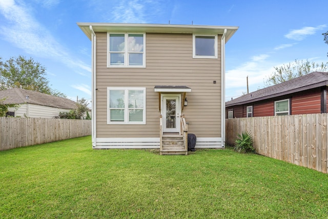 rear view of house featuring a lawn