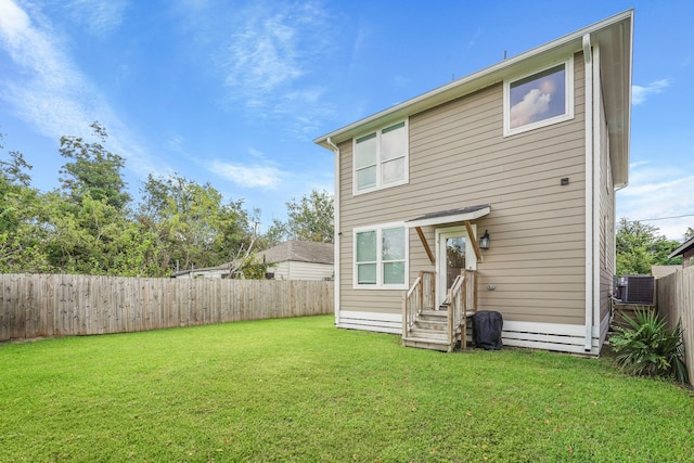 rear view of house featuring a yard and central AC unit