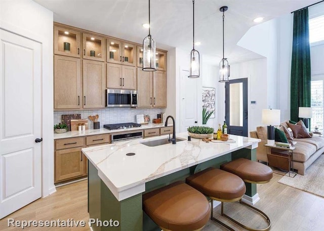 kitchen with appliances with stainless steel finishes, a center island with sink, a wealth of natural light, and sink