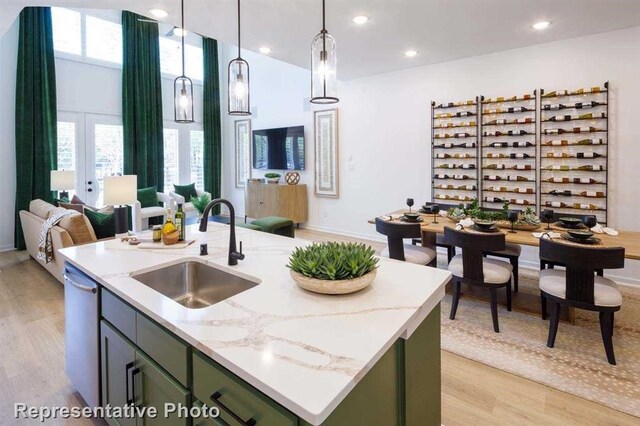 kitchen with a center island with sink, plenty of natural light, decorative light fixtures, and sink