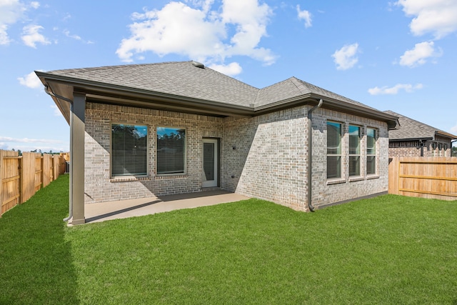 rear view of house with a yard and a patio area