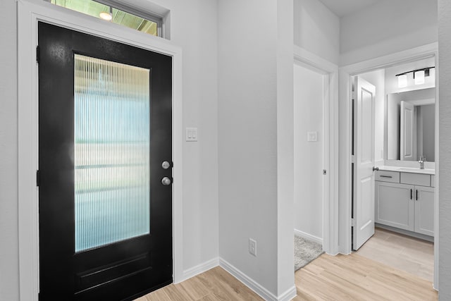 entrance foyer featuring sink and light wood-type flooring